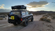 Overlanding rig equipped with roof top tent and yellow weekend warrior first aid kit