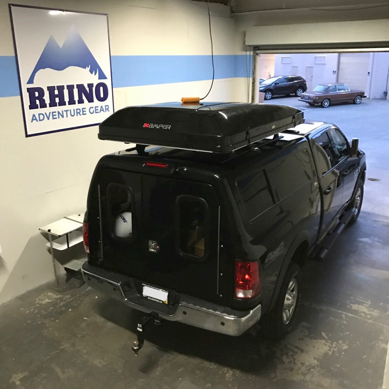 black Ram 2500 truck at Rhino Adventure Gear Showroom with camper topper and newly installed Rhino Rack Roof Rack and iKamper Skycamp Roof Top Tent 