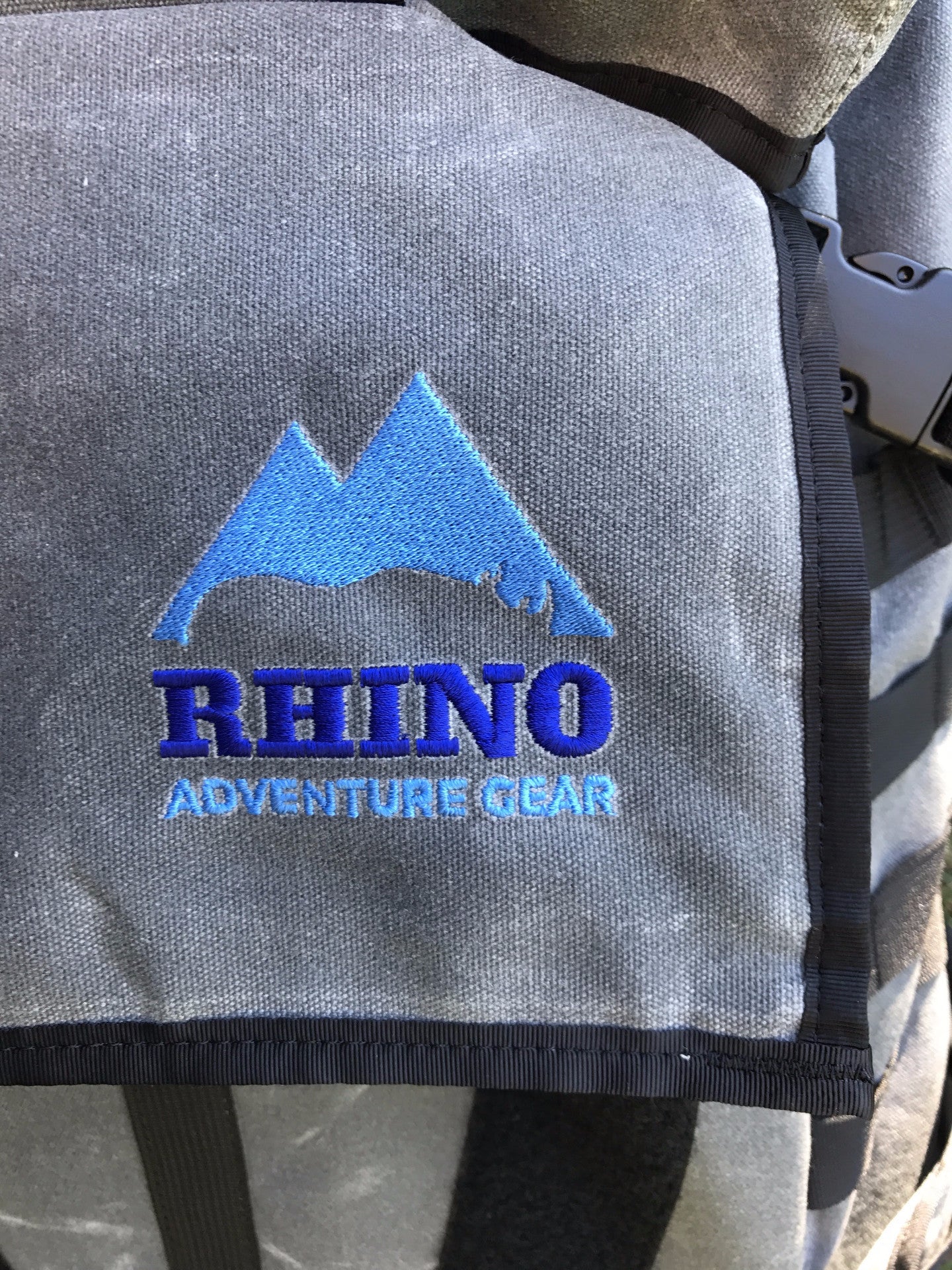 Detail of embroidered Rhino Adventure Gear logo stitched onto top flap of Adventure Backpack