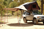 iKamper Skycamp roof top tent awning shown from passenger side of vehicle with awning extending over roof top tent ladder area