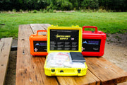 Three types of trauma kits for off road travelers, shown with yellow weekend warrior first aid kit opened on picnic table