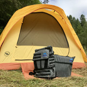 Adventure Tote Bag and Adventure Backpack, both grey with black trim and blue Rhino Adventure Gear logo shown leaning against yellow and orange tent