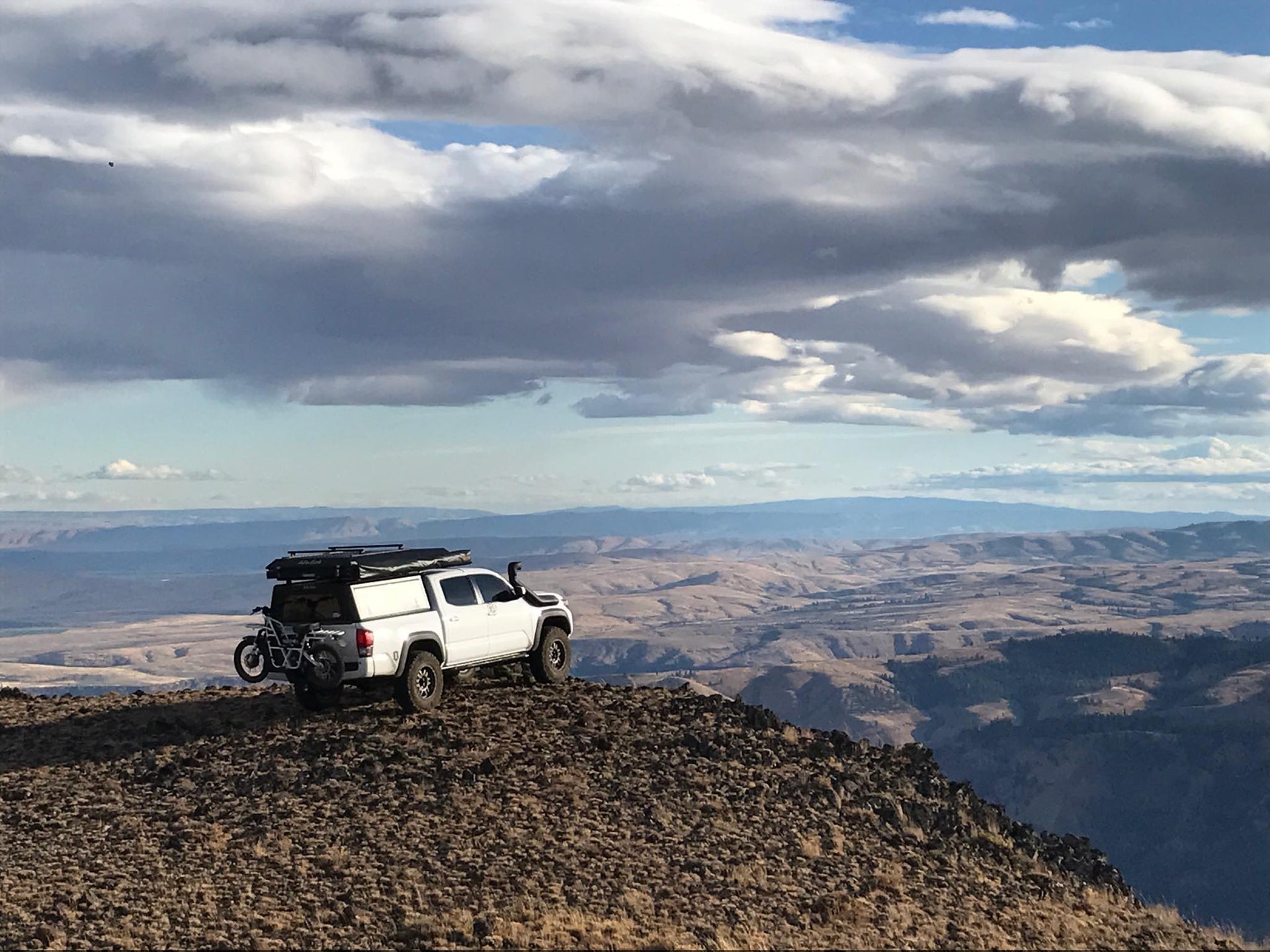 Ubco 2x2 off-road electric adventure bike available at Rhino Adventure Gear shown mounted on back of overlanding rig
