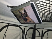 Tablet holder clipped to ceiling net in roof top tent