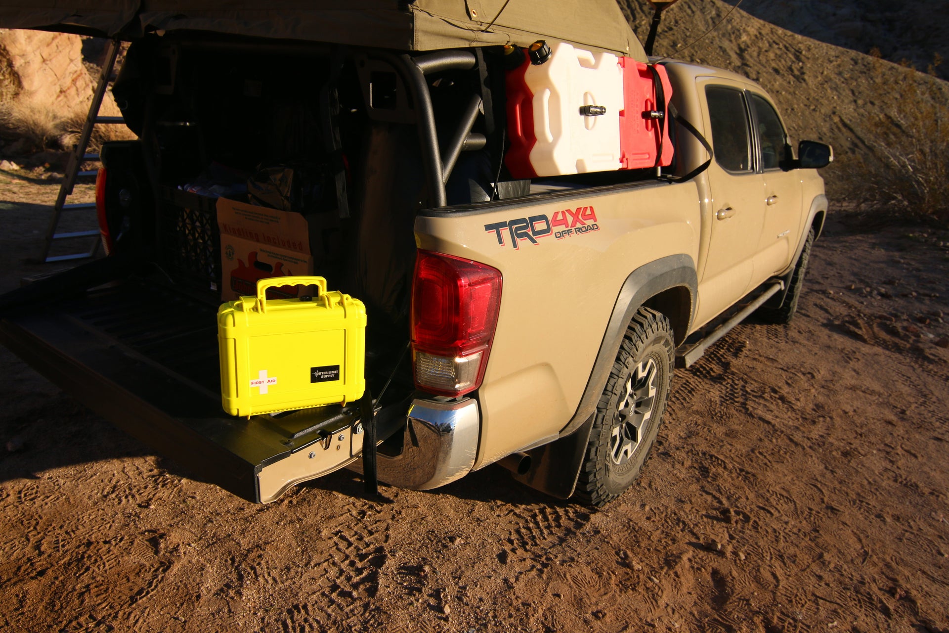 Off road truck with yellow camping first aid kit from Outer Limit Supply on tailgate
