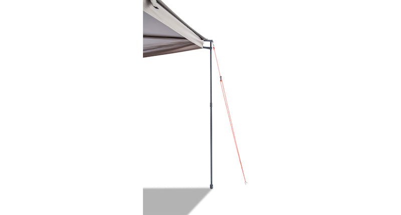 One corner of Batwing Awning shown set up with extended telescoping black leg and anchored with staked tie down rope