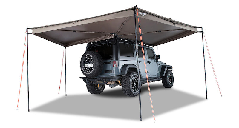 Right Side Mounted Rhino Rack Batwing Awning shown set up with 4 legs extended and tie downs staked in ground