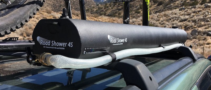 Road Shower 4S mounted on vehicle rack showing hose fitting to long black water tank