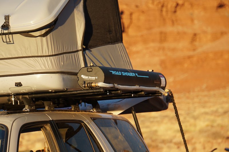 Road Shower 4 portable shower on roof rack next to james baroud space roof top tent