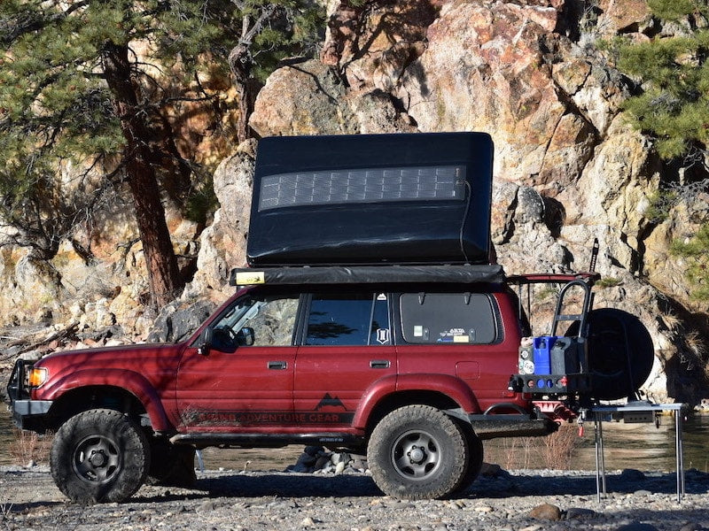 Red Toyota Landcruiser 80 series with black iKamper Skycamp roof top tent outfitted with SolarHawk overlanding solar panels