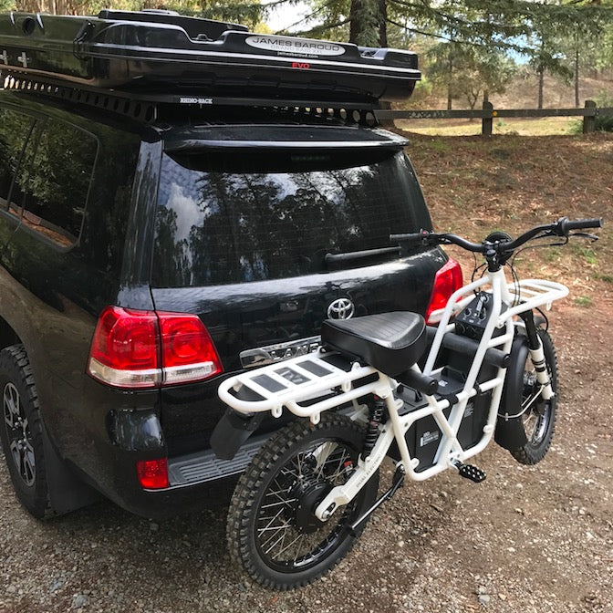 Ubco 2x2 Electric Adventure Bike shown mounted on Towball Bike Rack attached to back of black Toyota Landcruiser