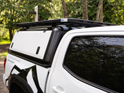 Side view of RLD stainless steel truck topper for Toyota Tacoma shown in black with white doors