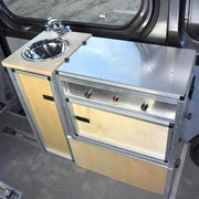 Trail Kitchens Van Kitchen installed behind passenger seat in sprinter van shown with detachable kitchen unit in place next to sink