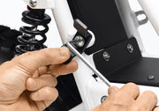 Detail of hands installing a tube adapter bracket from the 2x2 Adapter Pack to a lug on the Ubco 2x2 Electric Adventure Bike frame.