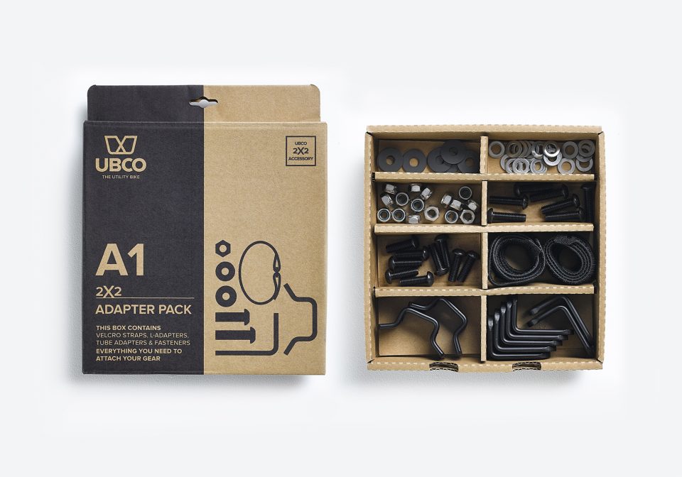 Ubco 2x2 Adapter Pack showing inside and outside of product packaging. The inside of the box is divided into 8 compartments to organize the various nuts, bolts, washers, L-brackets, and tube adapters that comprise the 2x2 Adapter Pack