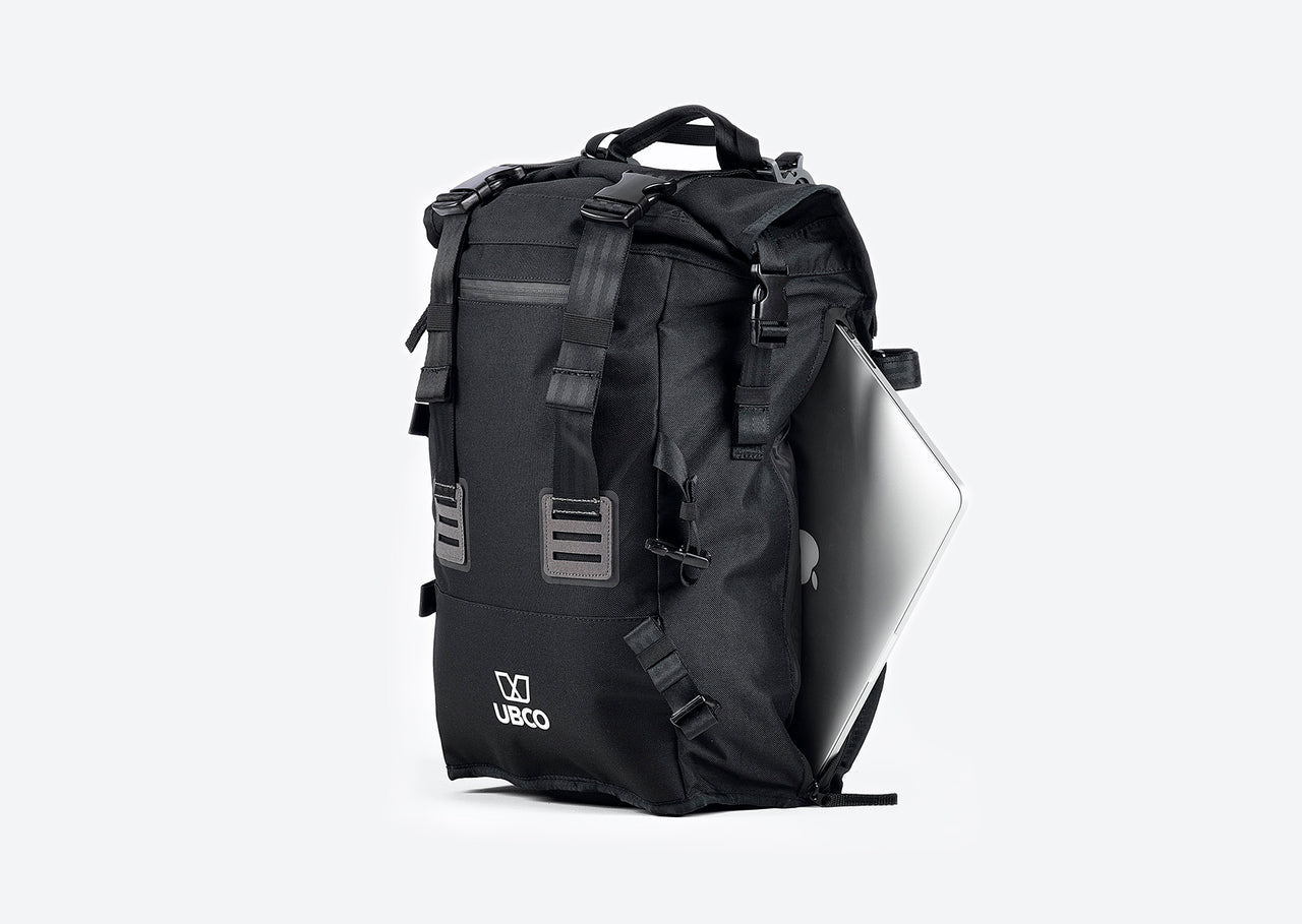 Black Pannier Backpack compatible with Ubco 2x2 Pannier Racks shown with a laptop being slid into the 15" laptop compartment