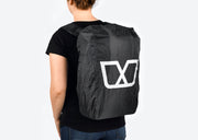 Black Pannier Backpack for Ubco 2x2 Electric Adventure Bike shown with removable rain cover protecting the bag. Rain cover for backpack is black with large white Ubco logo on the back. Backpack is being modeled on a person's back.