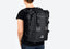 Black Pannier Backpack for Ubco 2x2 Electric Adventure Bike. Backpack is being modeled on a person's back