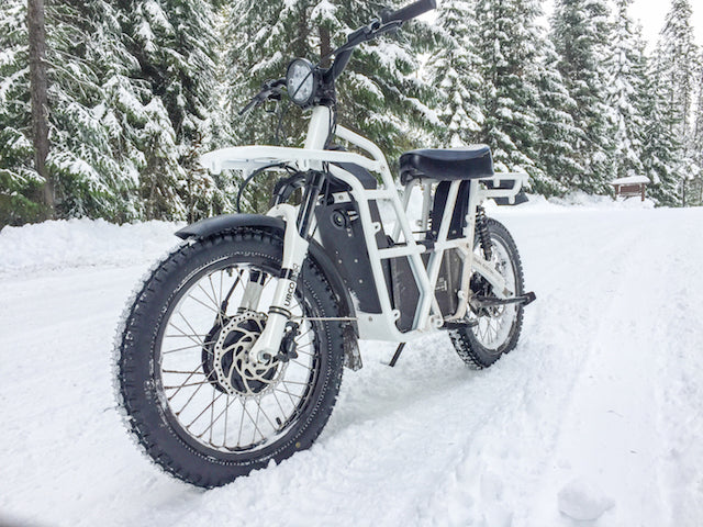 Ubco 2x2 off-road electric adventure bike available at Rhino Adventure Gear shown riding in snow