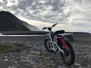 ubco 2x2 2017 off road electric adventure bike from Rhino Adventure Gear shown on sandy beach overlooking california coastline